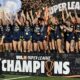 The Tampa Bay Sun raising their arms and celebrating on top of a stage that says USL Super League Champions.