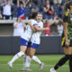 Ally Sentnor celebrates scoring a goal by hugging a teammate.