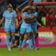 Ludmila celebrates with teammate Julia Grosso, who is embracing her, after scoring a goal.