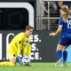 Kyra Carusa approaches Ann-Katrin Berger, who picks up a ball on the ground.